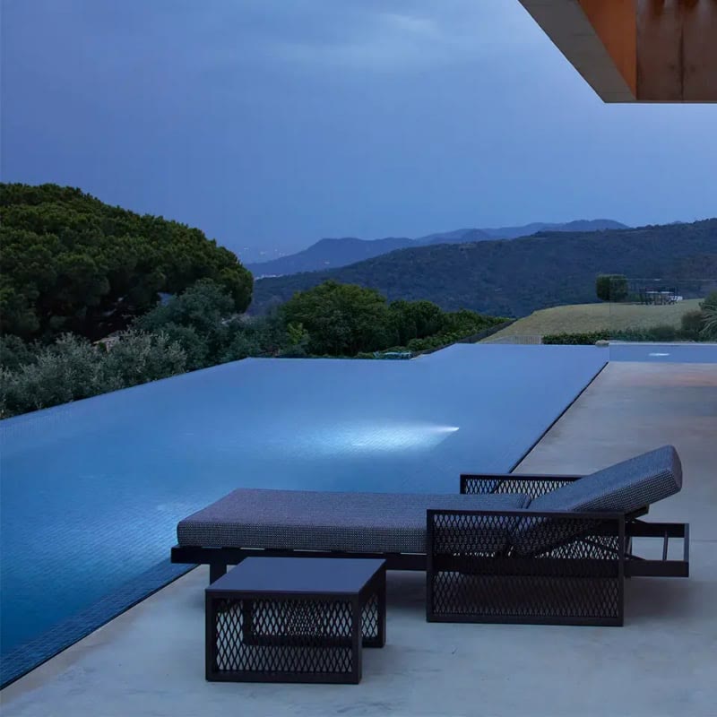 Bain de soleil THE FACTORY de VONDOM au bord d'une piscine au crépuscule