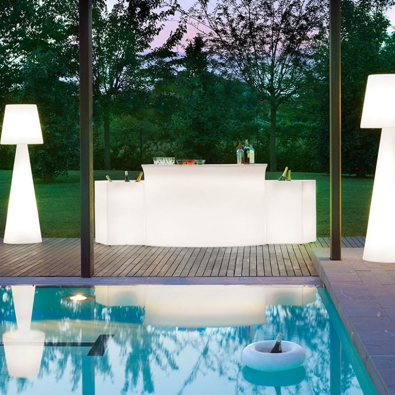 Comptoir lumineux au bord d'une piscine dans un jardin