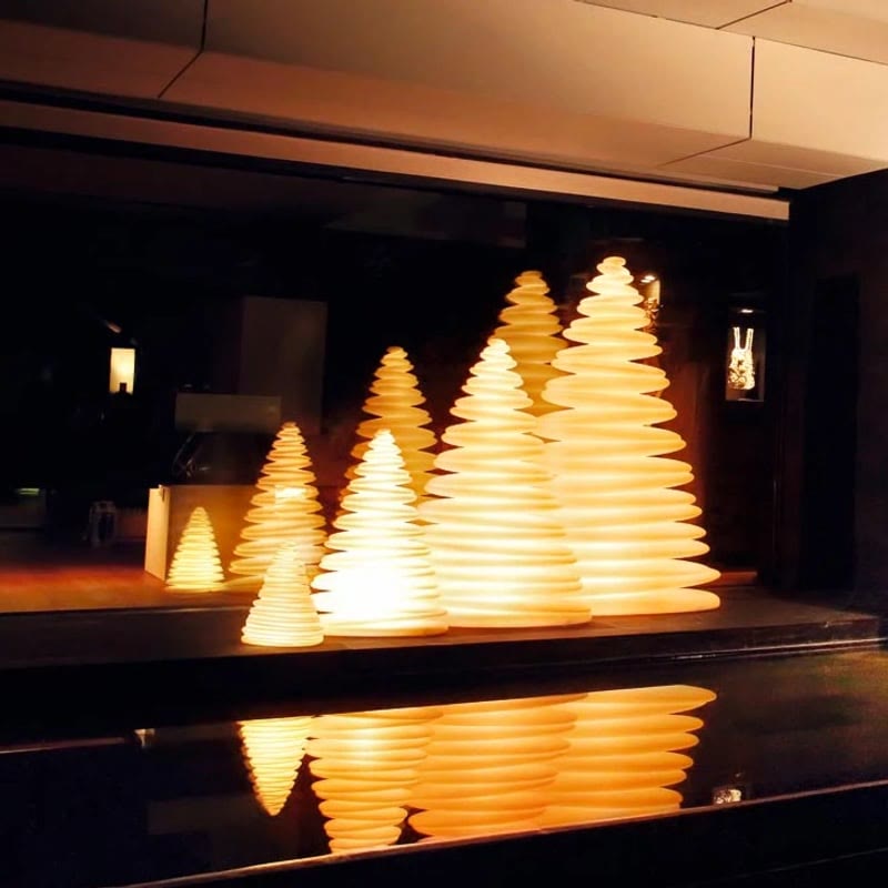 Sapins CHRISMY de VONDOM se reflétant dans un bassin