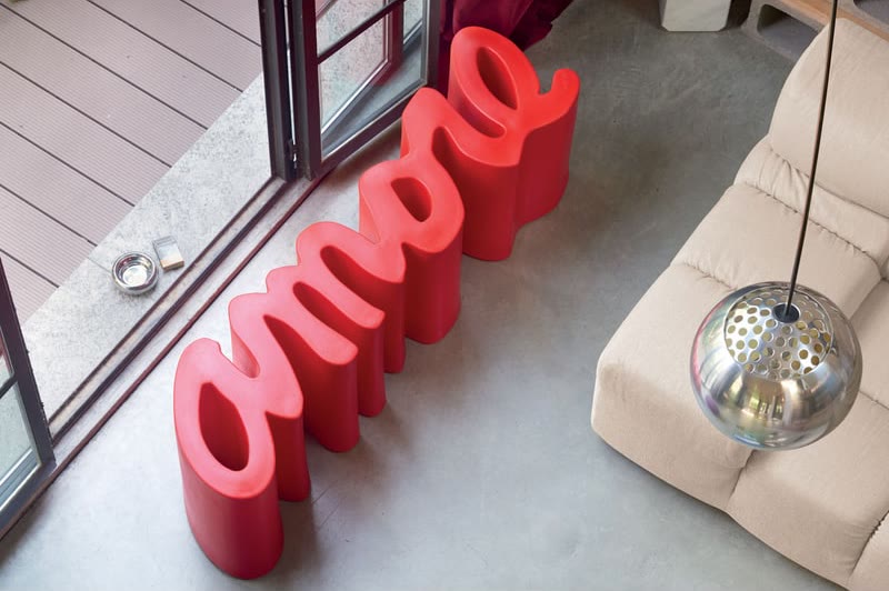 Banc AMORE de SLIDE rouge dans un intérieur