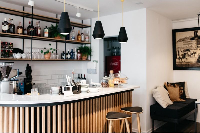 Suspensions noires coniques au-dessus d'un comptoir de bar avec tabourets hauts